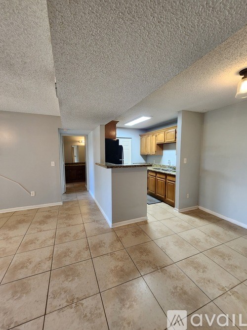 A living room with a kitchen in the background.