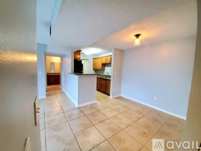 A living room with a kitchen in the background.