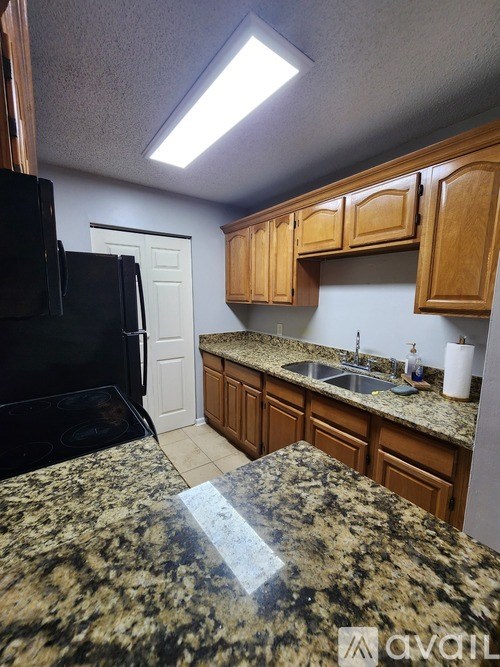 A kitchen with granite countertops and wooden cabinets.