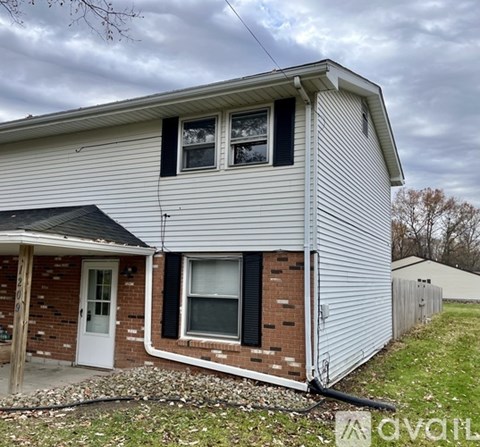 A house with a white siding and a brick foundation.