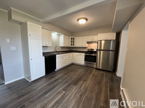 A kitchen with white cabinets and a stainless steel refrigerator.