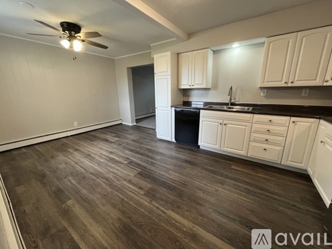 A kitchen with white cabinets and a dark countertop.