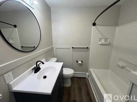 A bathroom with a white sink, toilet, and bathtub.