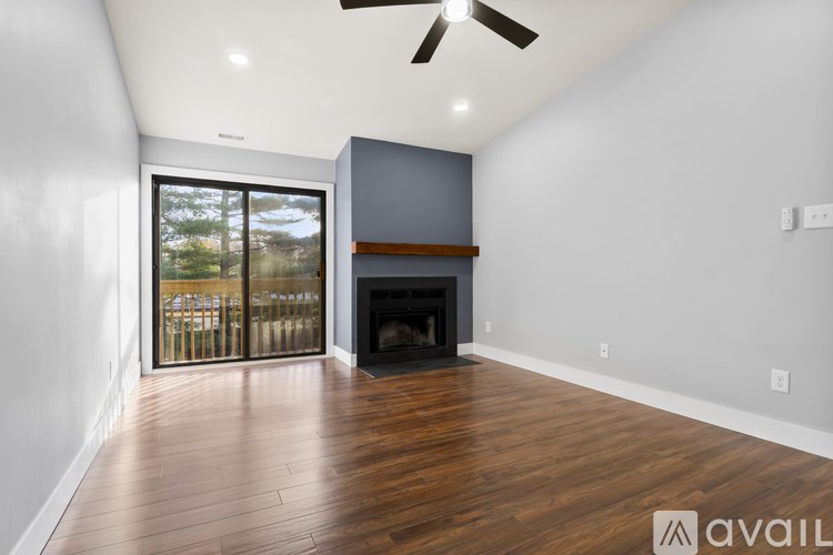 A spacious room with a fireplace and a ceiling fan.