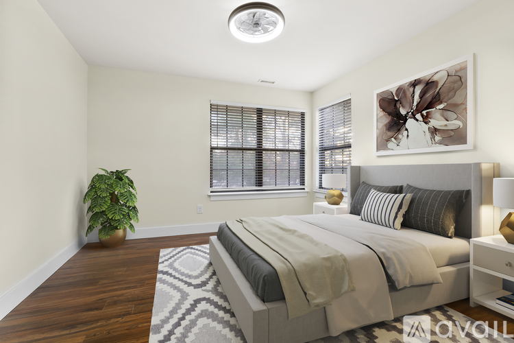 A bedroom with a large bed and a potted plant.