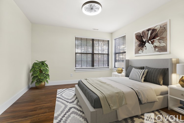 A bedroom with a large bed and a potted plant.