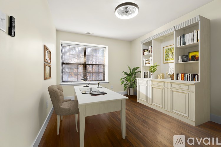 A room with a desk, chair, and bookshelf.