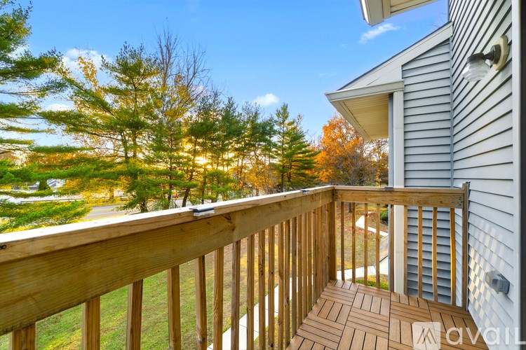 A wooden deck with a railing and a house in the background.
