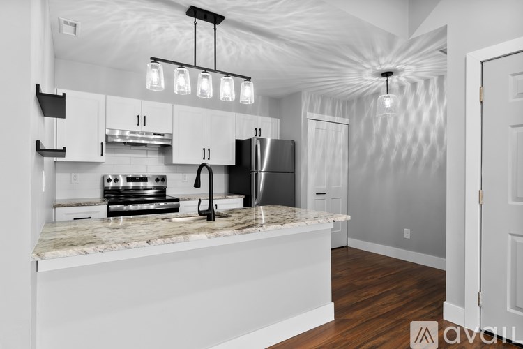 A kitchen with white cabinets and a marble countertop.