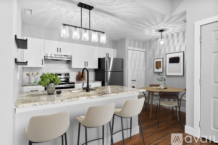 A modern kitchen with white cabinets and a marble countertop.