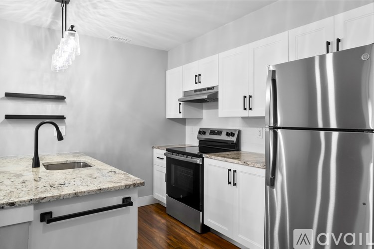 A kitchen with a granite countertop and stainless steel appliances.