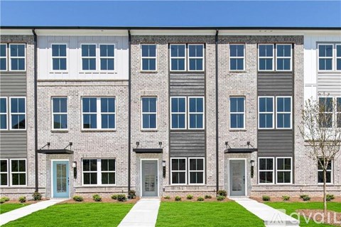 A row of modern townhouses with grey and white exteriors and blue doors.