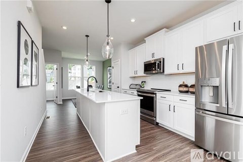 A modern kitchen with white cabinets and stainless steel appliances.
