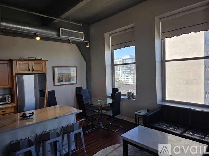 A living room with a bar area and a view of the city.