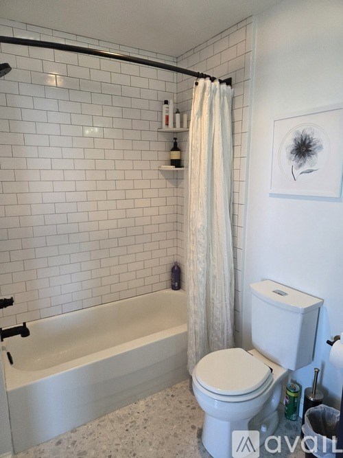A white toilet sits next to a bathtub in a bathroom.