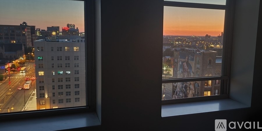 A cityscape view from a window at sunset.