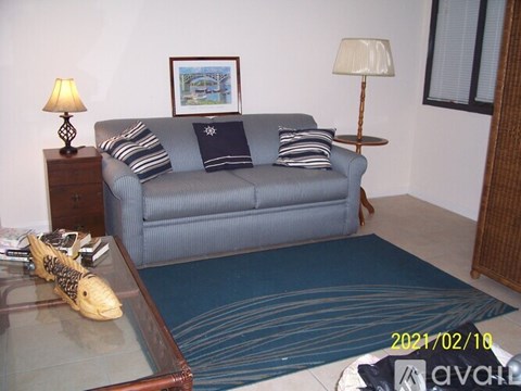 A living room with a blue couch and a wooden side table.