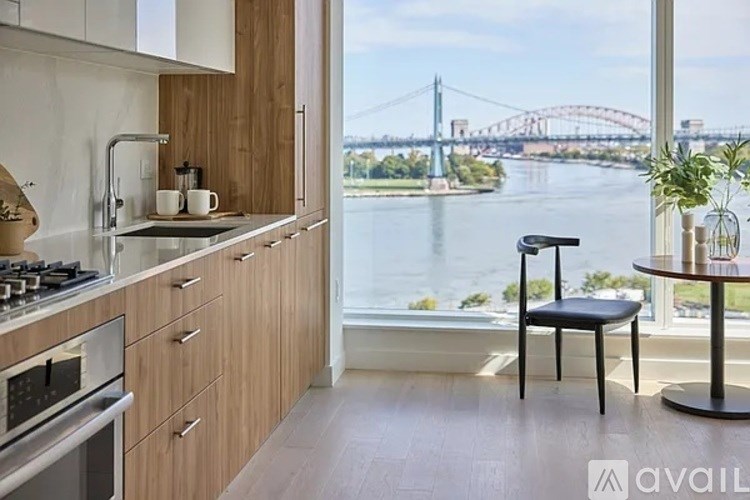 A kitchen with a view of a bridge over a river.