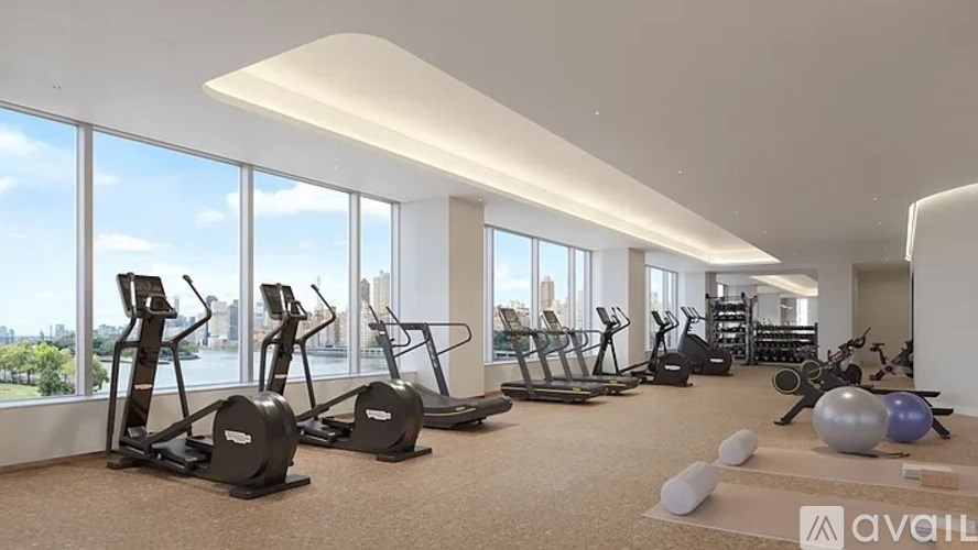 A gym with a row of treadmills and exercise balls.