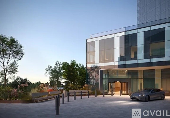 A modern building with a glass facade and a car parked in front.