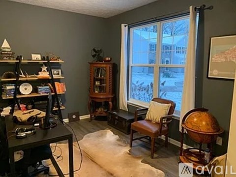 A room with a desk, chair, and a globe.