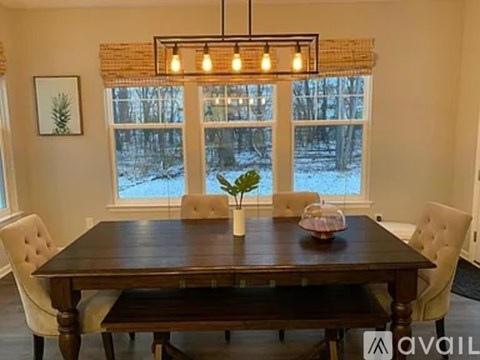A dining room with a wooden table and chairs.