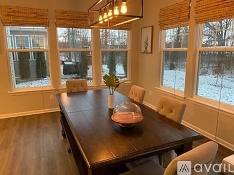 A dining room with a wooden table and chairs.