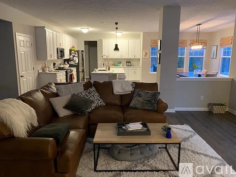 A living room with a brown leather couch and a coffee table.