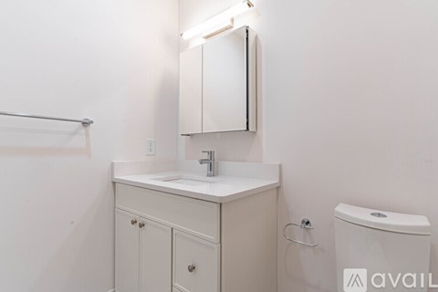 A bathroom with a sink, mirror, and toilet.