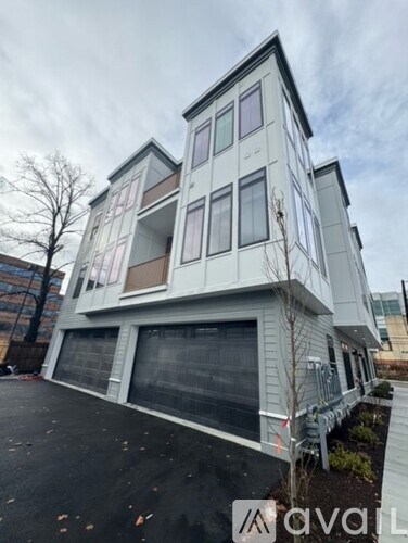 A modern two-story house with a grey exterior and large windows.