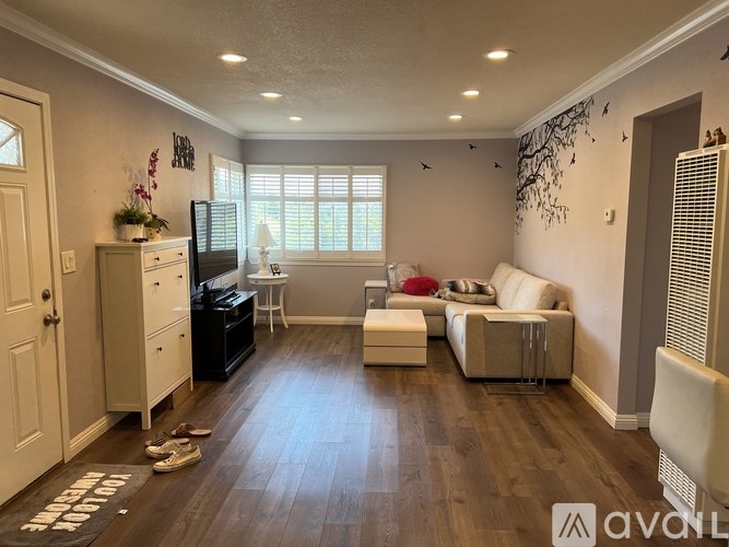 A living room with a white couch and a black TV.