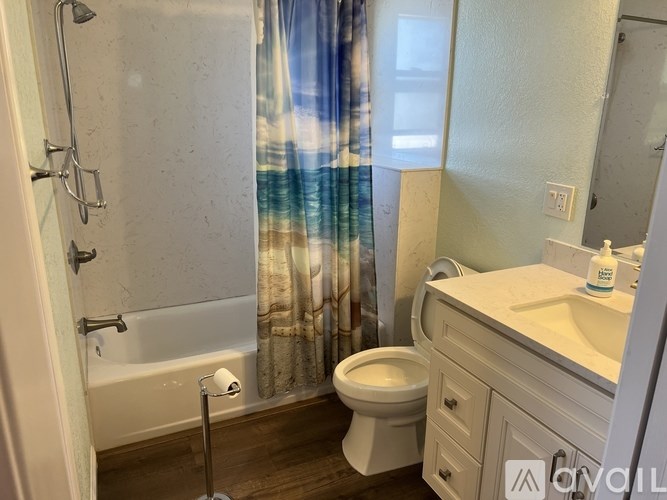 A bathroom with a toilet, sink, and shower.