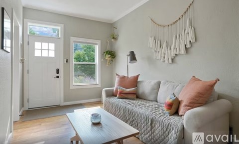 A living room with a couch, a coffee table, and a window.