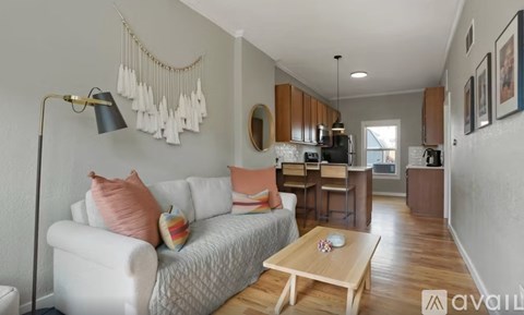 A living room with a white couch and a wooden coffee table.