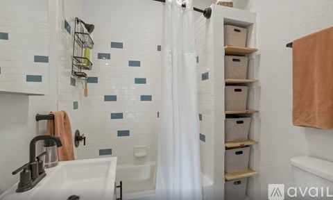 A bathroom with a white sink and a shower curtain.