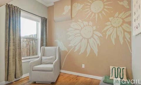A room with a sunflower wallpaper and a white chair.