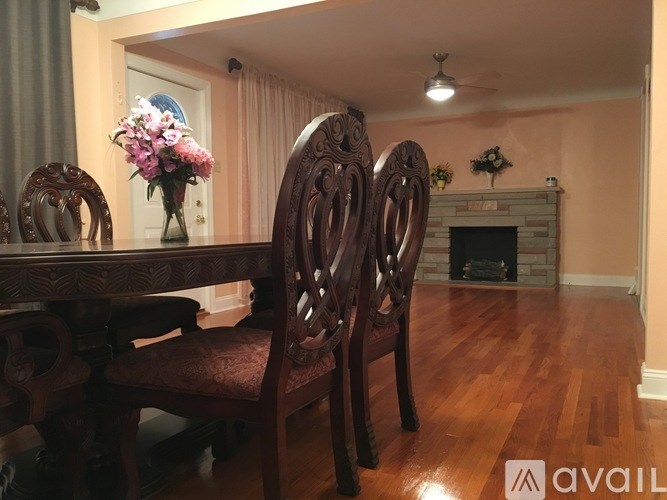 A dining room with a wooden table and chairs.