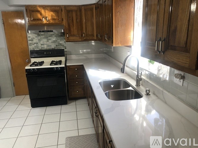 A kitchen with a black stove and wooden cabinets.