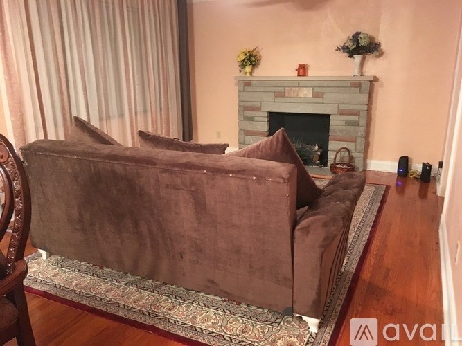 A brown couch is in front of a fireplace in a living room.