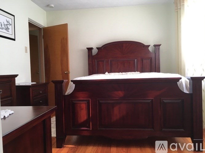 A bedroom with a bed, nightstand, and dresser.