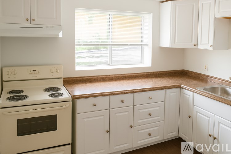 A kitchen with white cabinets and a stove top oven.