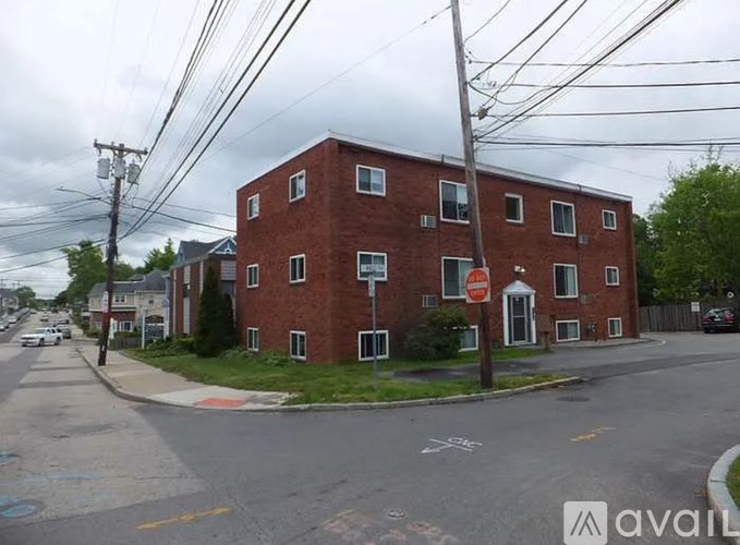 A red brick building with a white door and windows.
