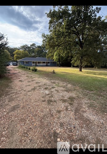 A gravel path leads to a house in a grassy area.