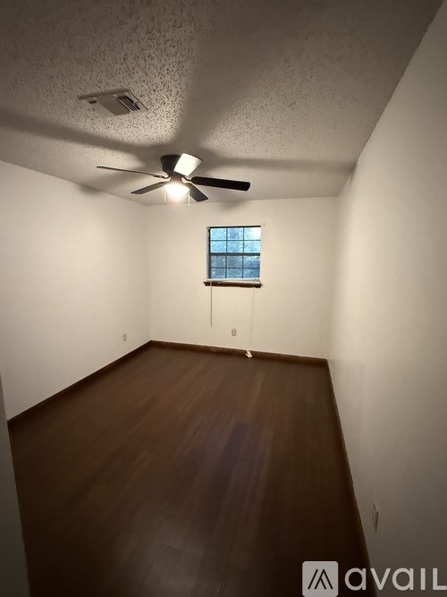 A room with a ceiling fan and a window.