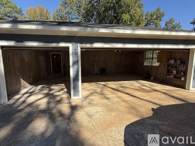 A garage with a concrete floor and a stone pillar.