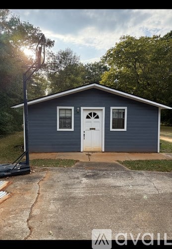 A small blue house with a white door and windows.