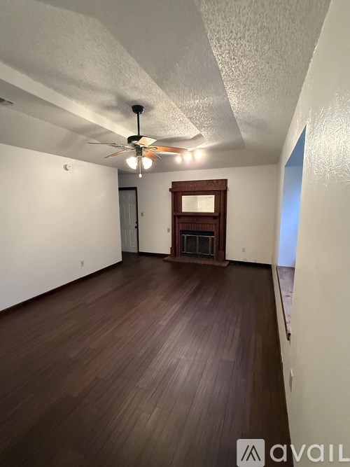 A room with wooden floors and a ceiling fan.