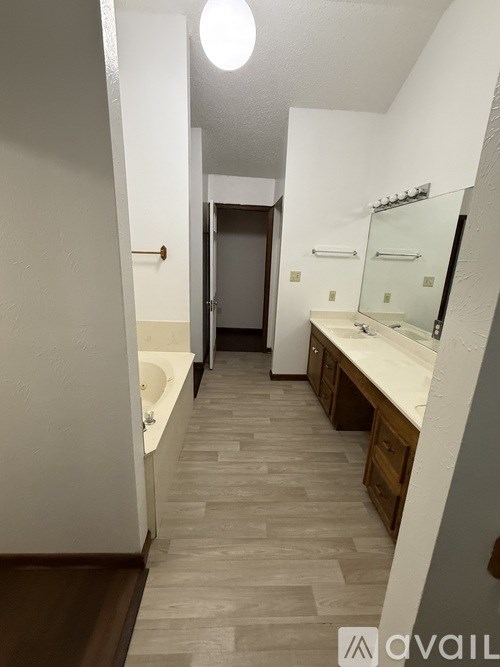 A bathroom with a sink, mirror, and bathtub.