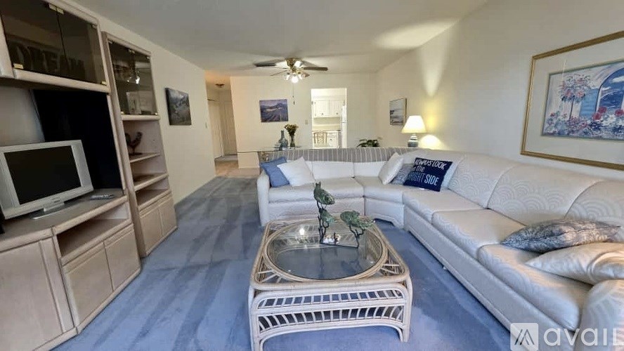 A living room with a white couch and a coffee table.