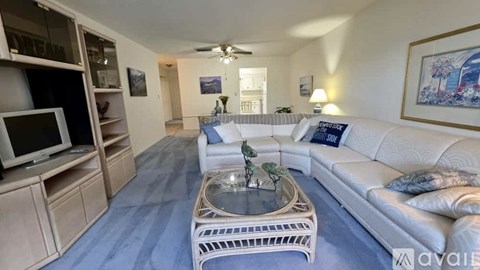 A living room with a white couch and a coffee table.